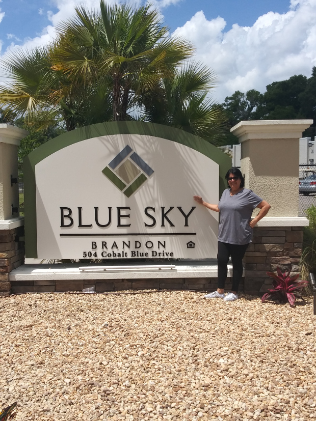 Haydee standing in front of the Blue Sky Brandon sign